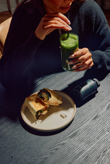 Girl in black shirt having a shake alongside food and a blood sugar supplement