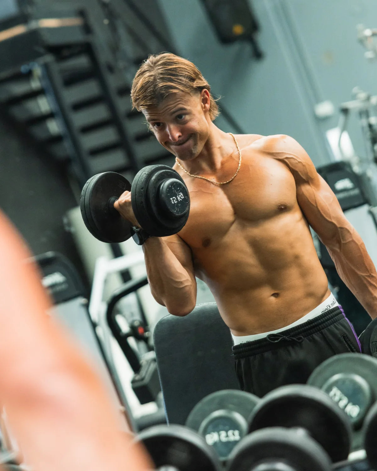 Anabolic Gabe curling a dumbbell in the gym mirror