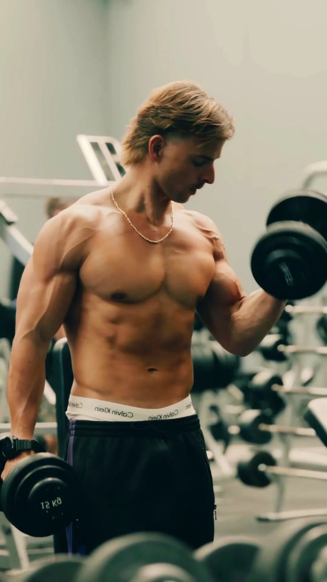 Gabe curling a dumbbell in the gym