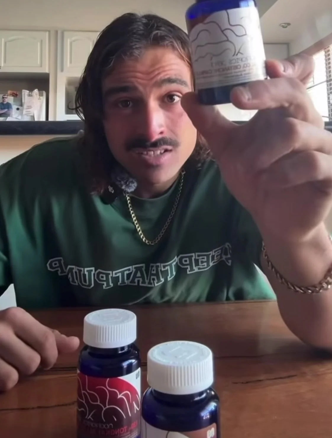 Rambo holding up a bottle of black ginger with other herb bottles on the table